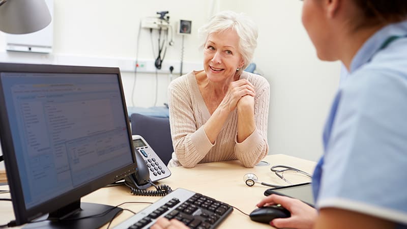 An older woman talking to a nurse about her Annual Wellness Visit.